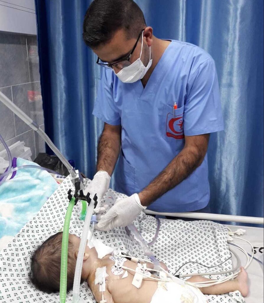Health worker treats infant child in Gaza with pneumonia